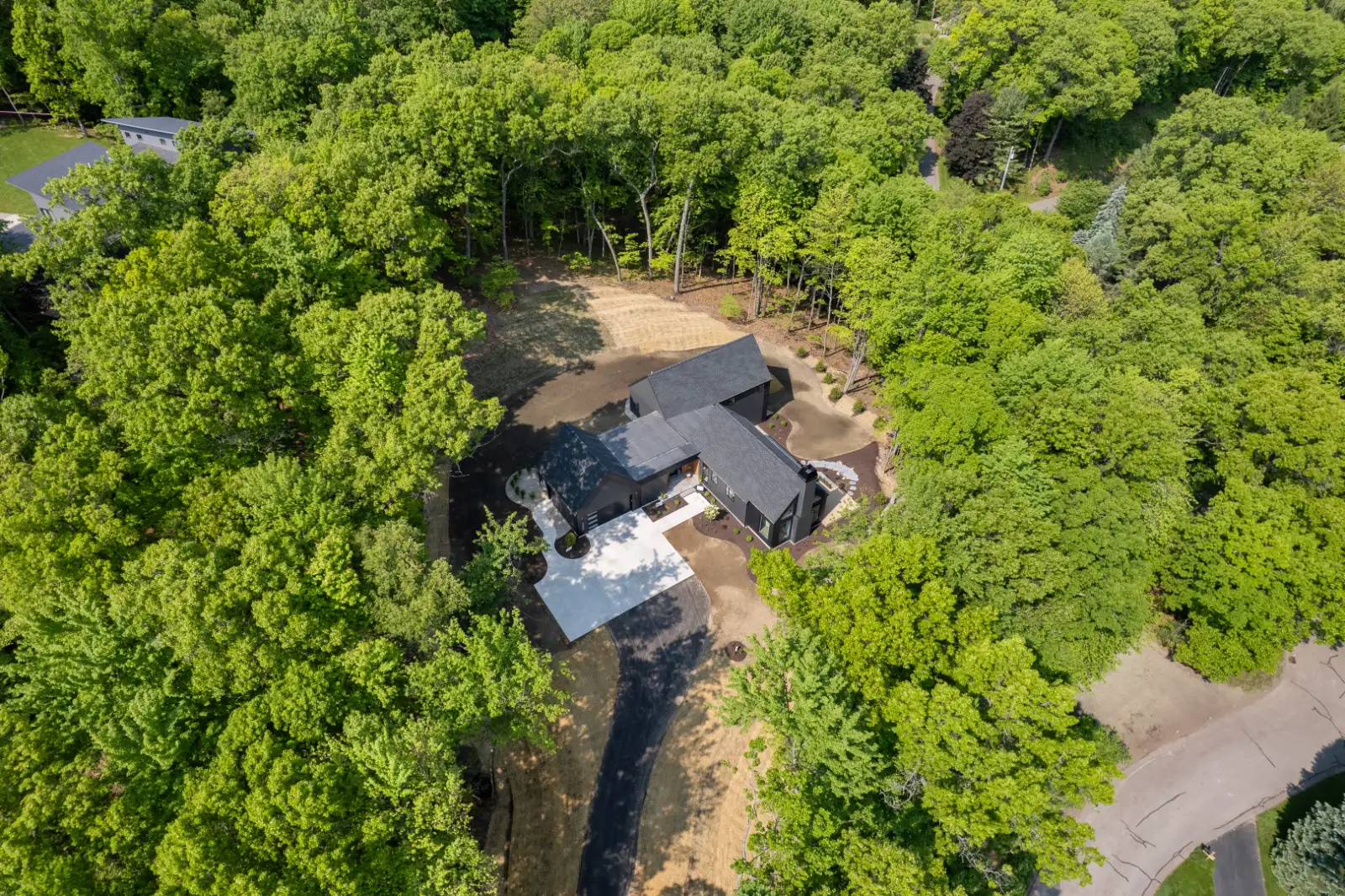 Aerial, house sited among mature hardwoods