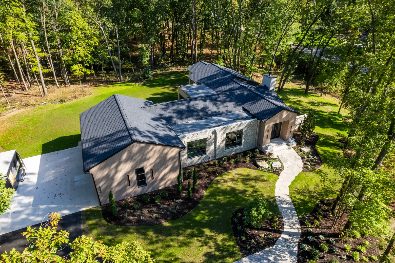 Aerial, the house read against the drive and the hardwoods
